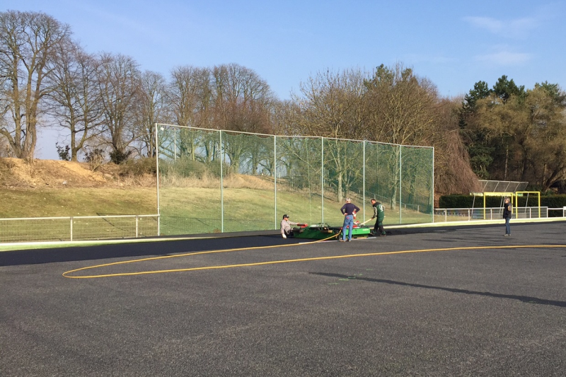 16.03.2015 Mit einem Mini-Straßenfertiger wird die Schicht bahnenweise aufgetragen