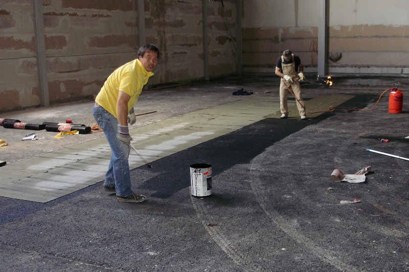 04.07.07 Als Vorbereitung für den Sportboden wird eine Wassersperre aus Dachpappe warm verlegt (Technik-Chef Volker immer in Aktion)